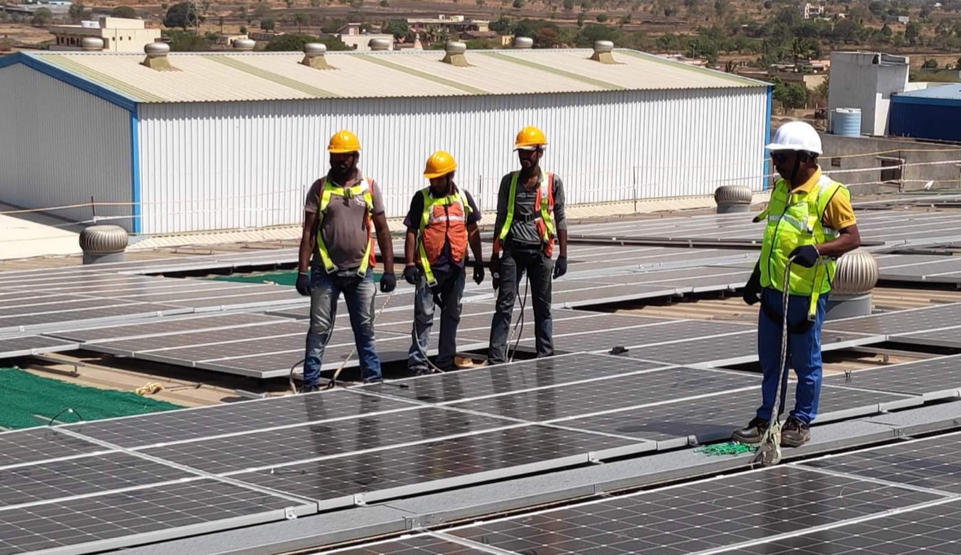 AmPrisia installation crew in safety gear on a factory rooftop solar plant